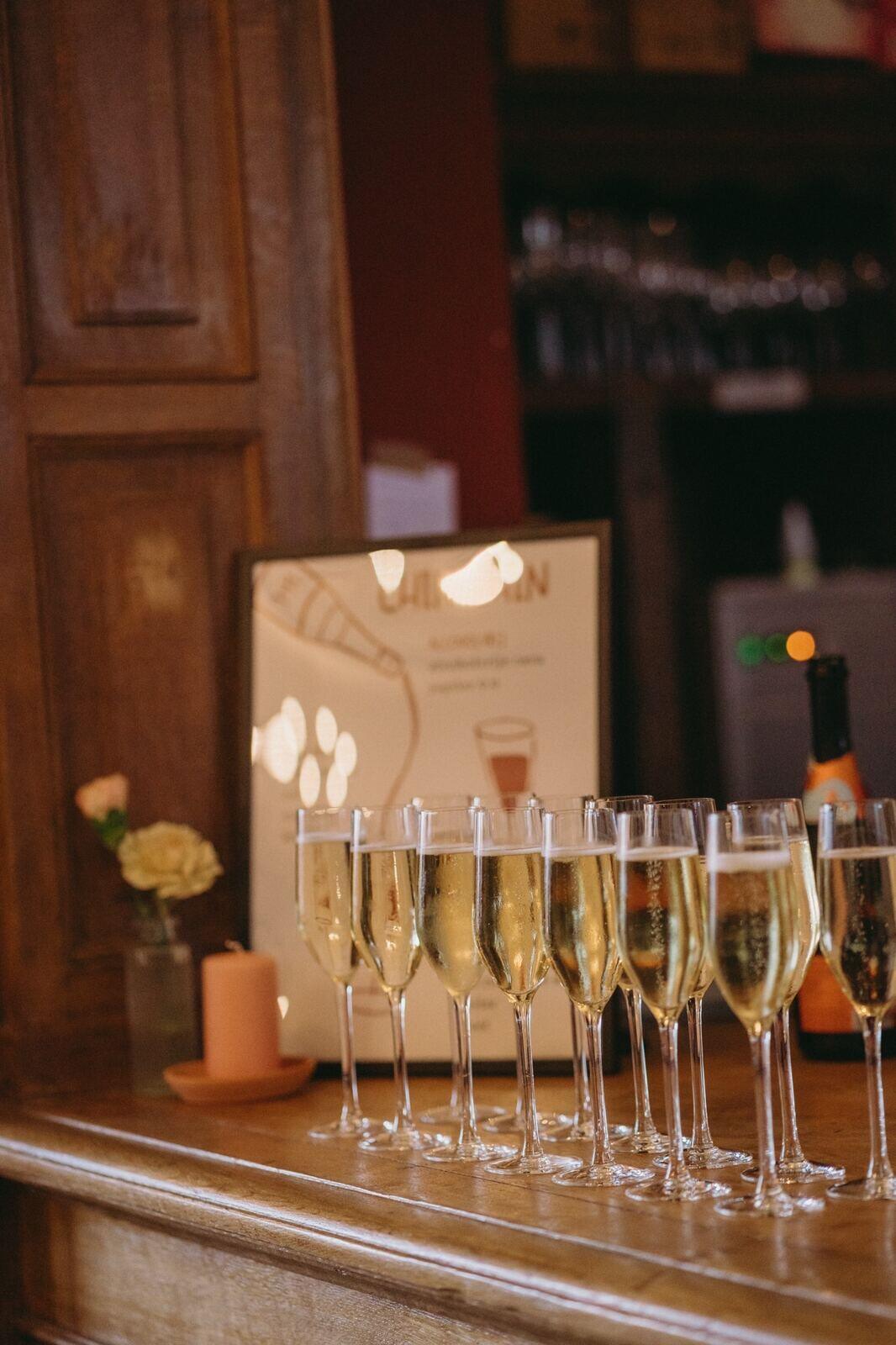 Rij gevulde champagneglazen op de houten toog