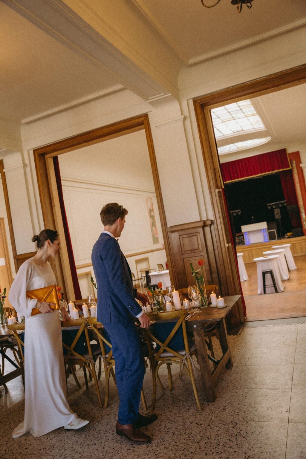 Bruidspaar in de feestzaal naast de gedekte tafels